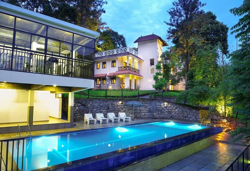 Swimming pool at Hotel Treetop, Thekkady, lit up at dusk